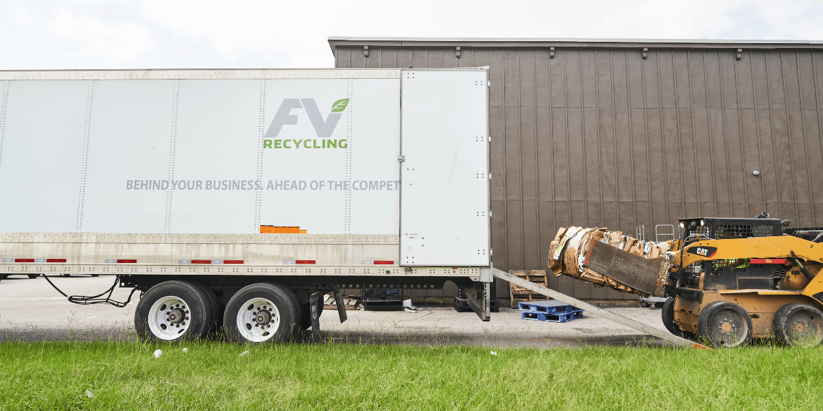 FV Recycling trailer being loaded with baled cardboard by a skid steer during a commercial recycling pickup