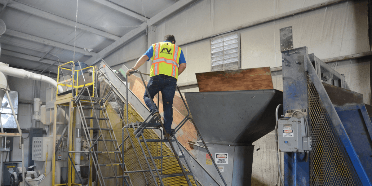 FV Recycling technician inspecting industrial recycling equipment during a waste and recycling audit at a commercial facility.