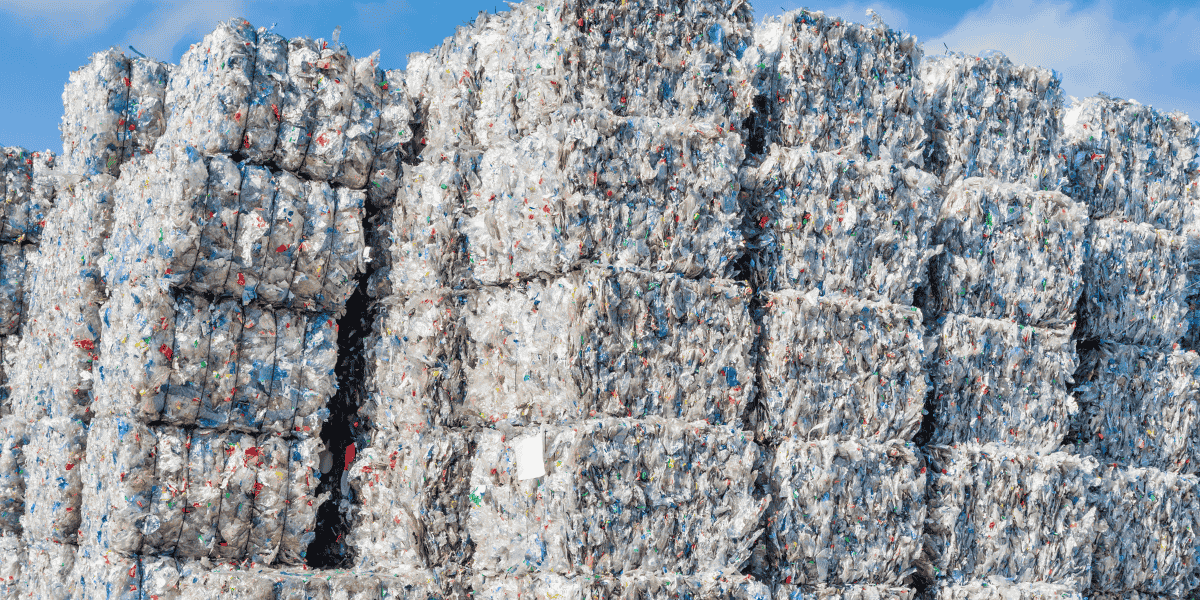 Recycled plastic bales stacked high outside of a business